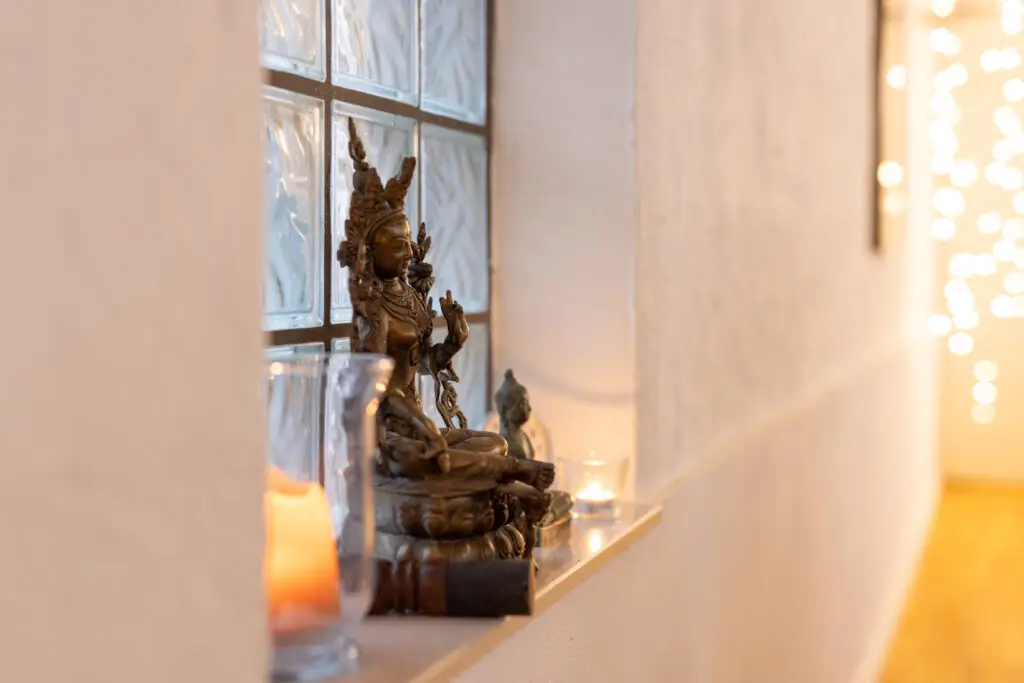 Buddhistische Statue mit Kerzen in warmem Licht