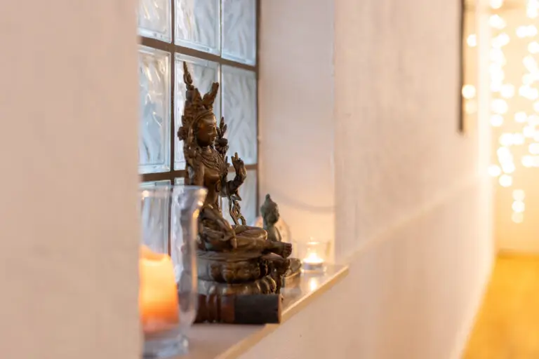 Buddhistische Statue mit Kerzen in warmem Licht