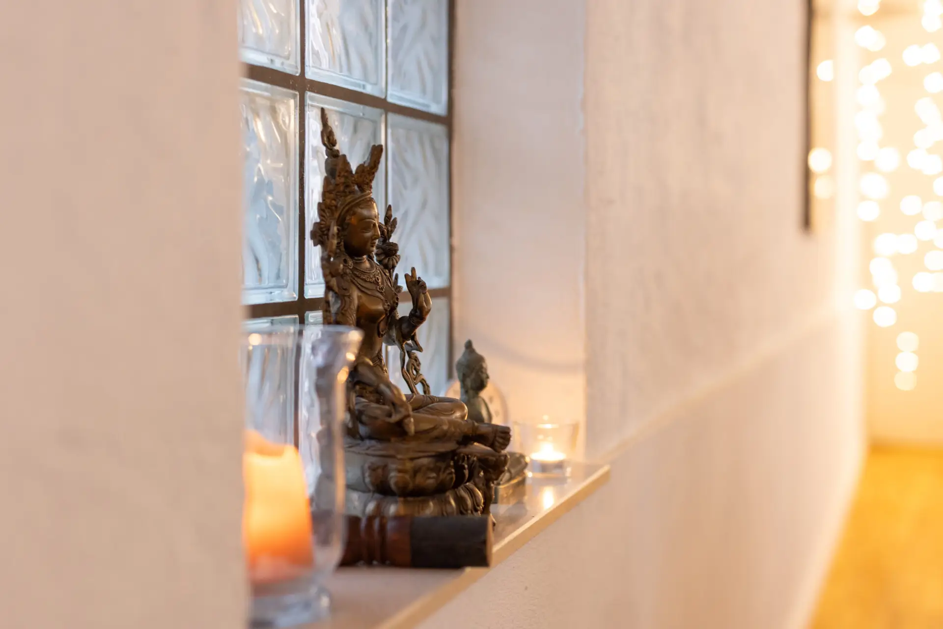 Buddhistische Statue mit Kerzen in warmem Licht