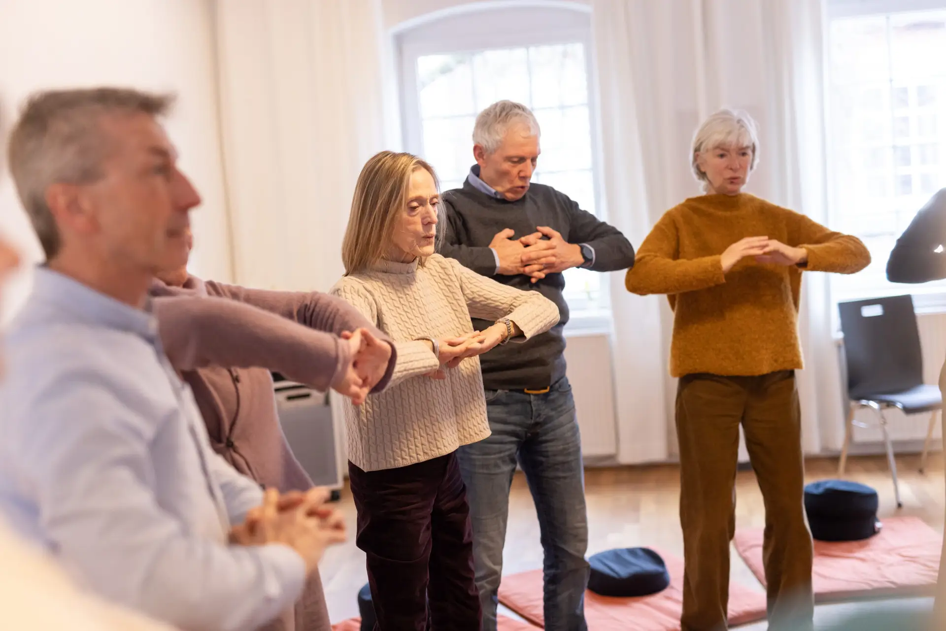 Menschen bei gemeinsamer Achtsamkeitsübung im Stehen.