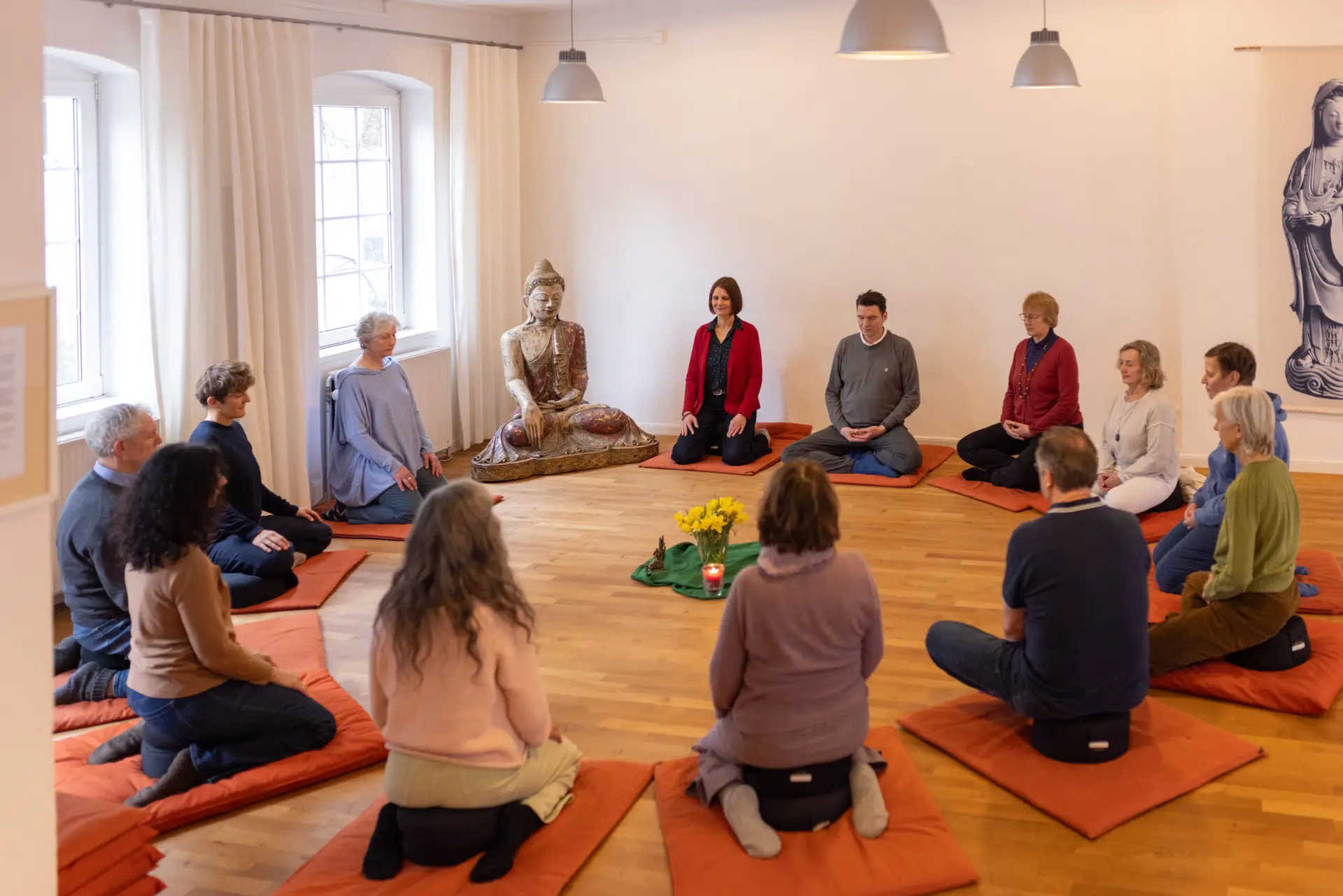 Meditationsgruppe sitzt gemeinsam in stiller Runde.