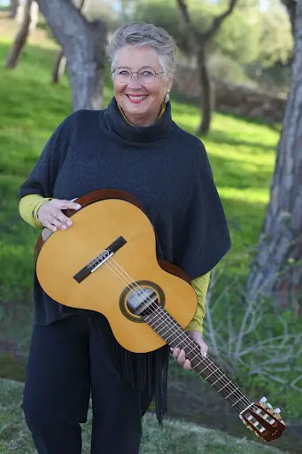 Glückliche Dame mit schönen Hintergrund und Gitarre in der Hand